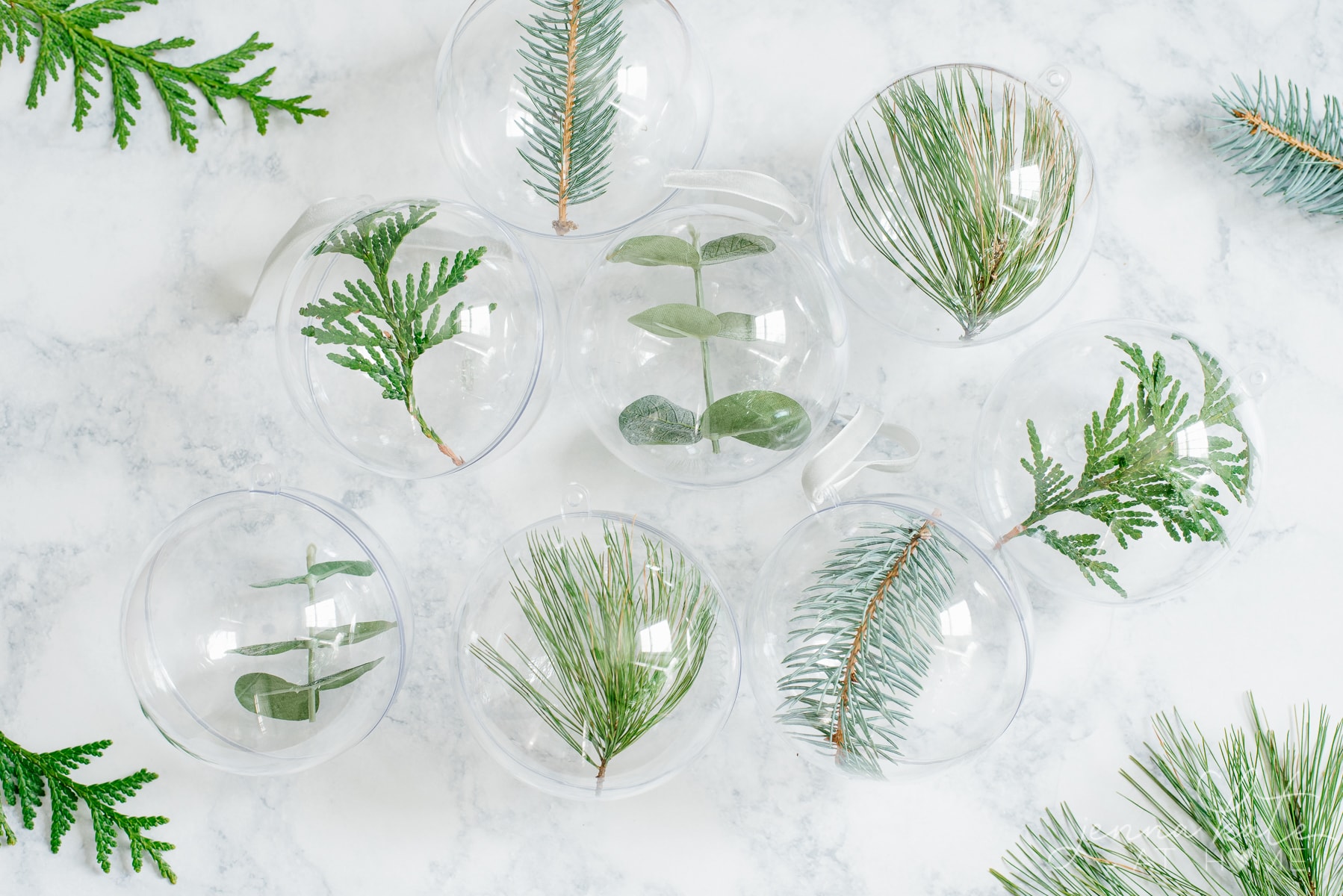 DIY minimalist Christmas tree ornaments filled with fresh greenery