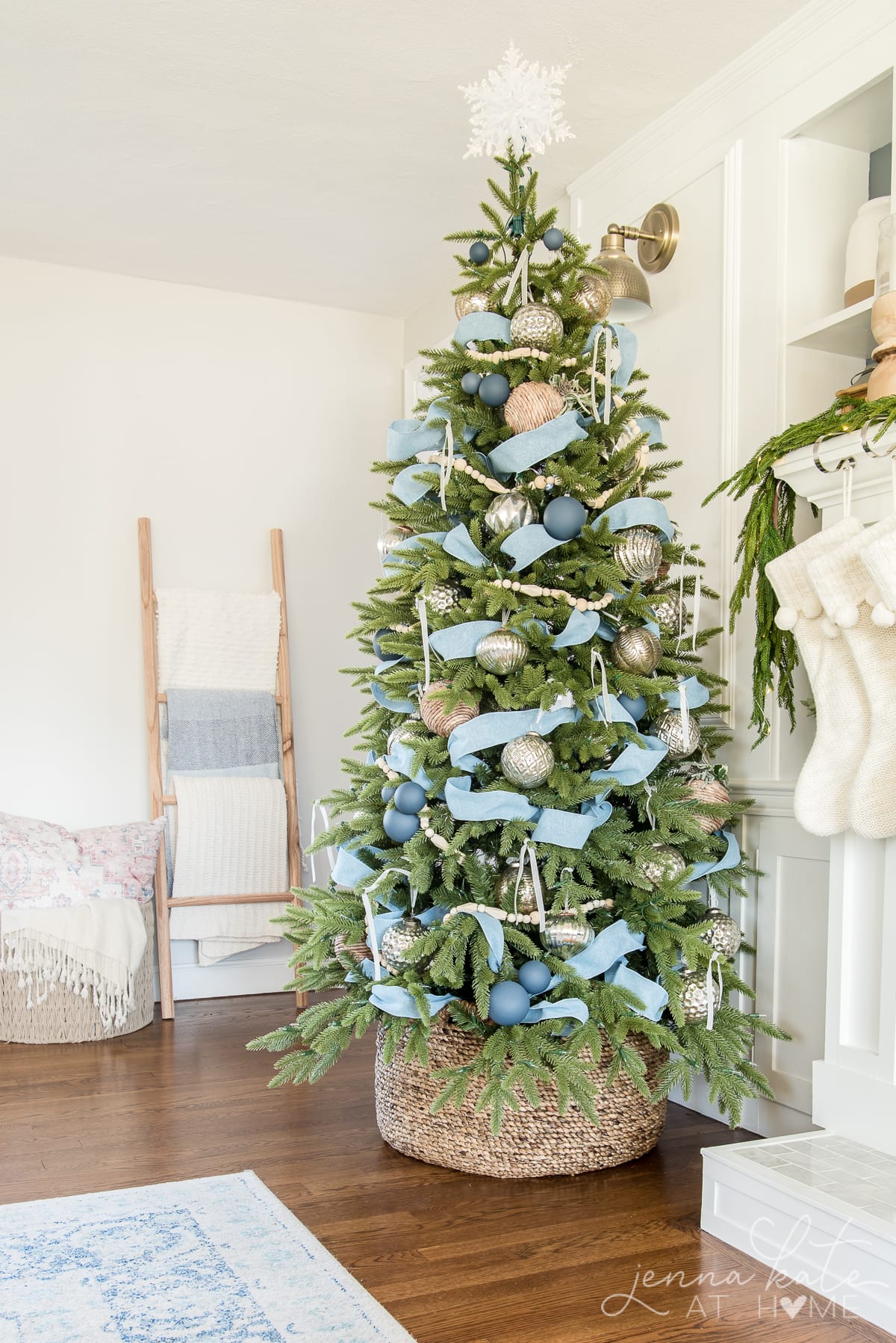 Christmas tree with blue decorations inside a woven tree collar