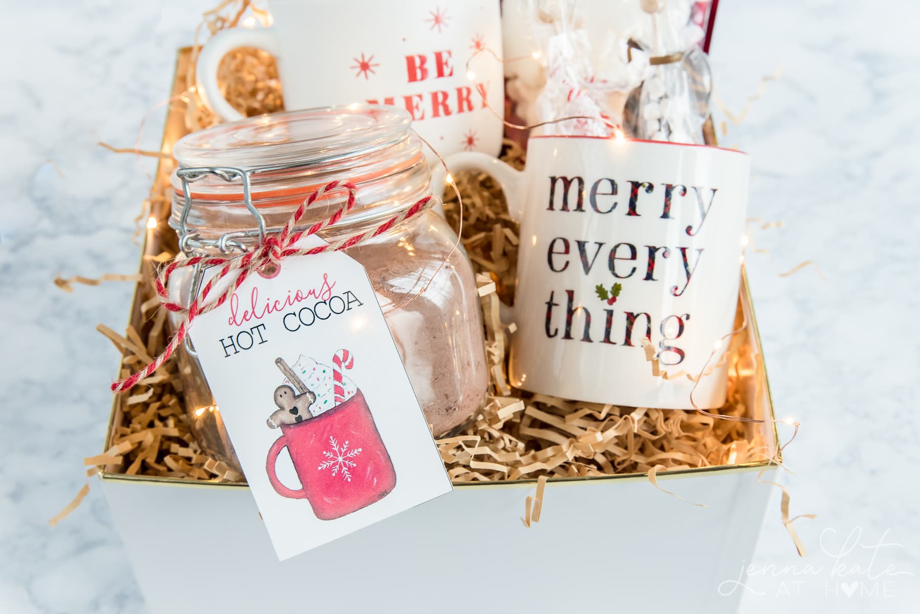 Hot chocolate gift basket idea with homemade mix, Christmas mugs, stir sticks and marshmallows