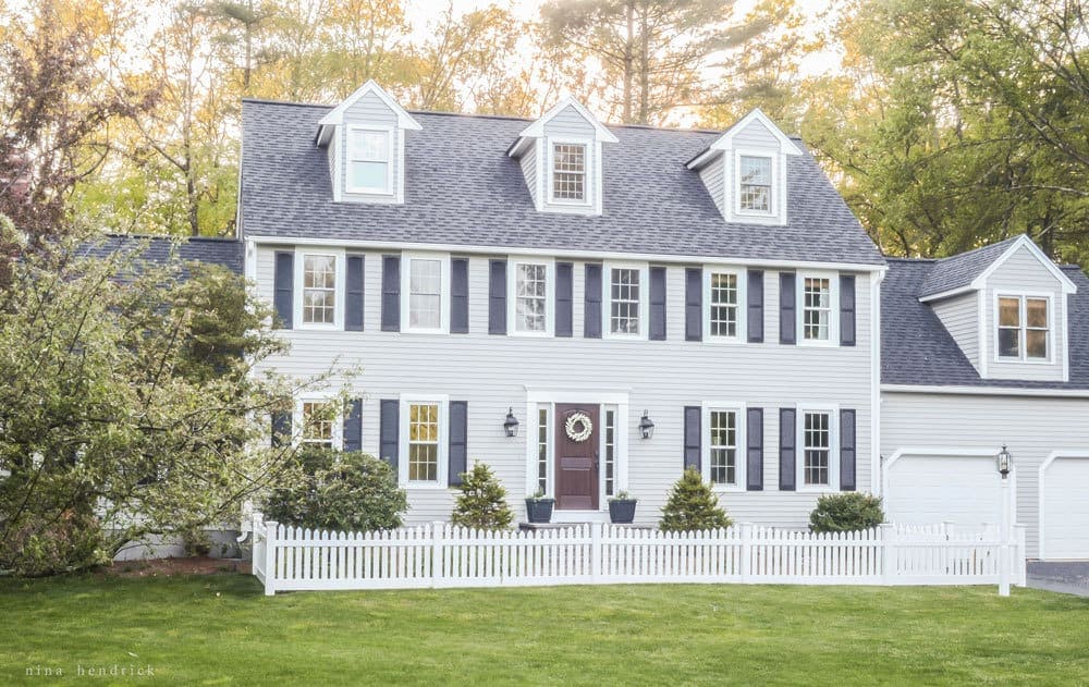 A large lawn in front of a colonial house