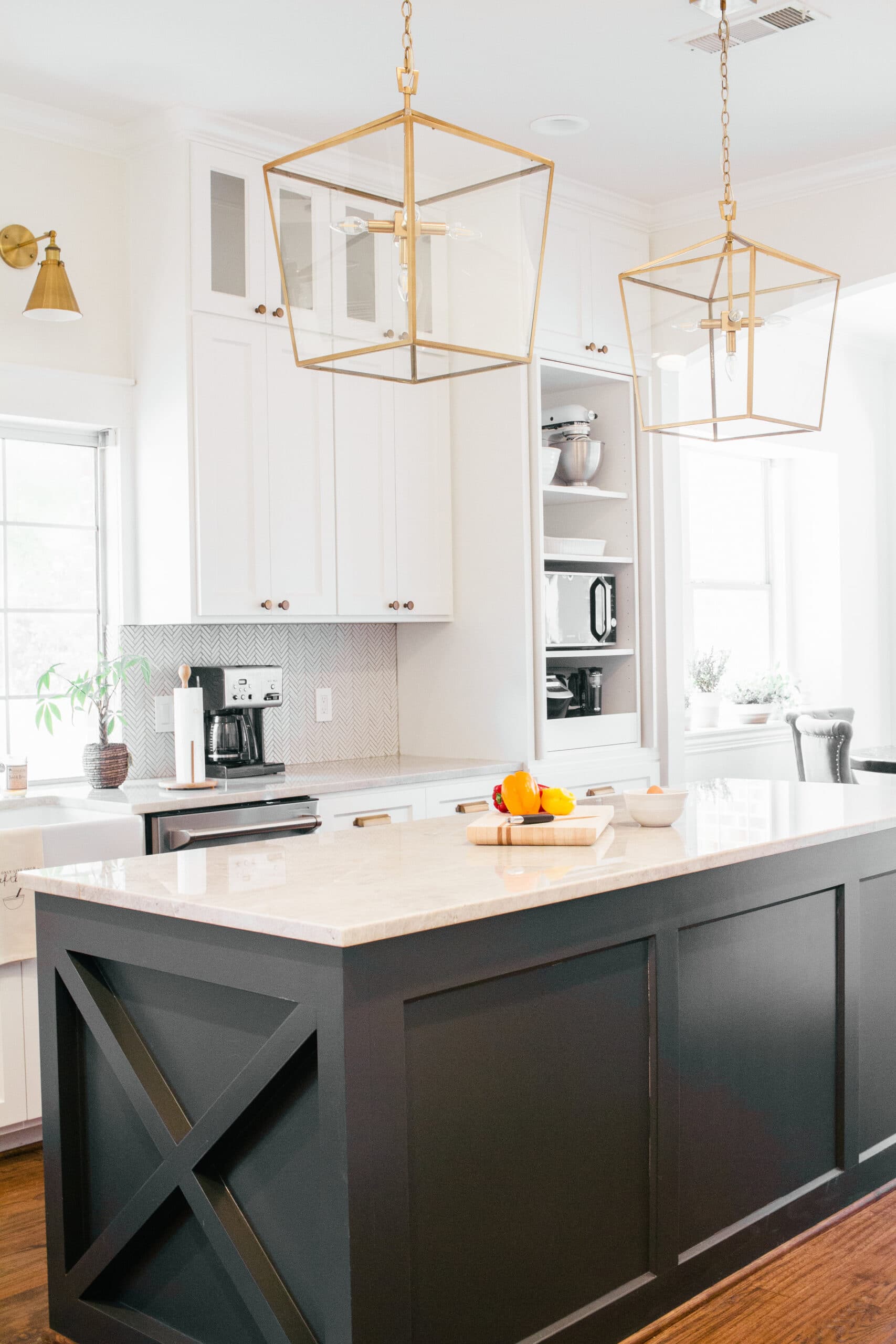 SW Iron Ore painted kitchen island with pure white cabinets and gold lantern pendants