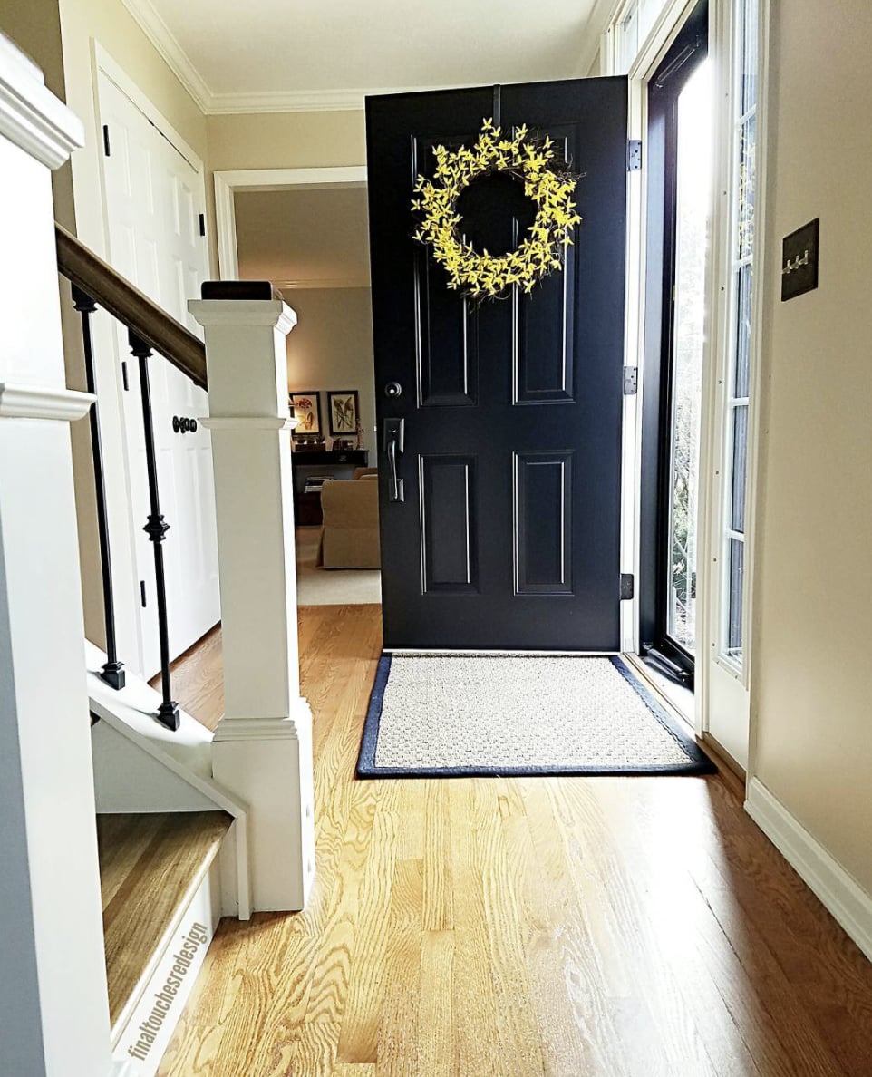 entryway with black front door and walls painted sherwin williams kilim beige