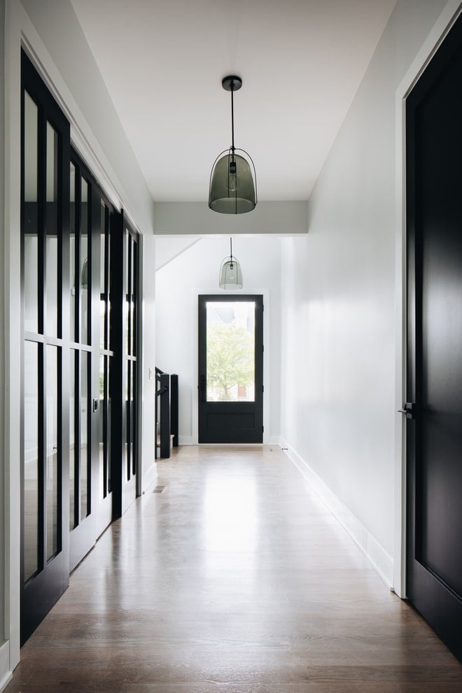 Sherwin Williams Iron Ore painted on  interior doors of a long bright hallway.