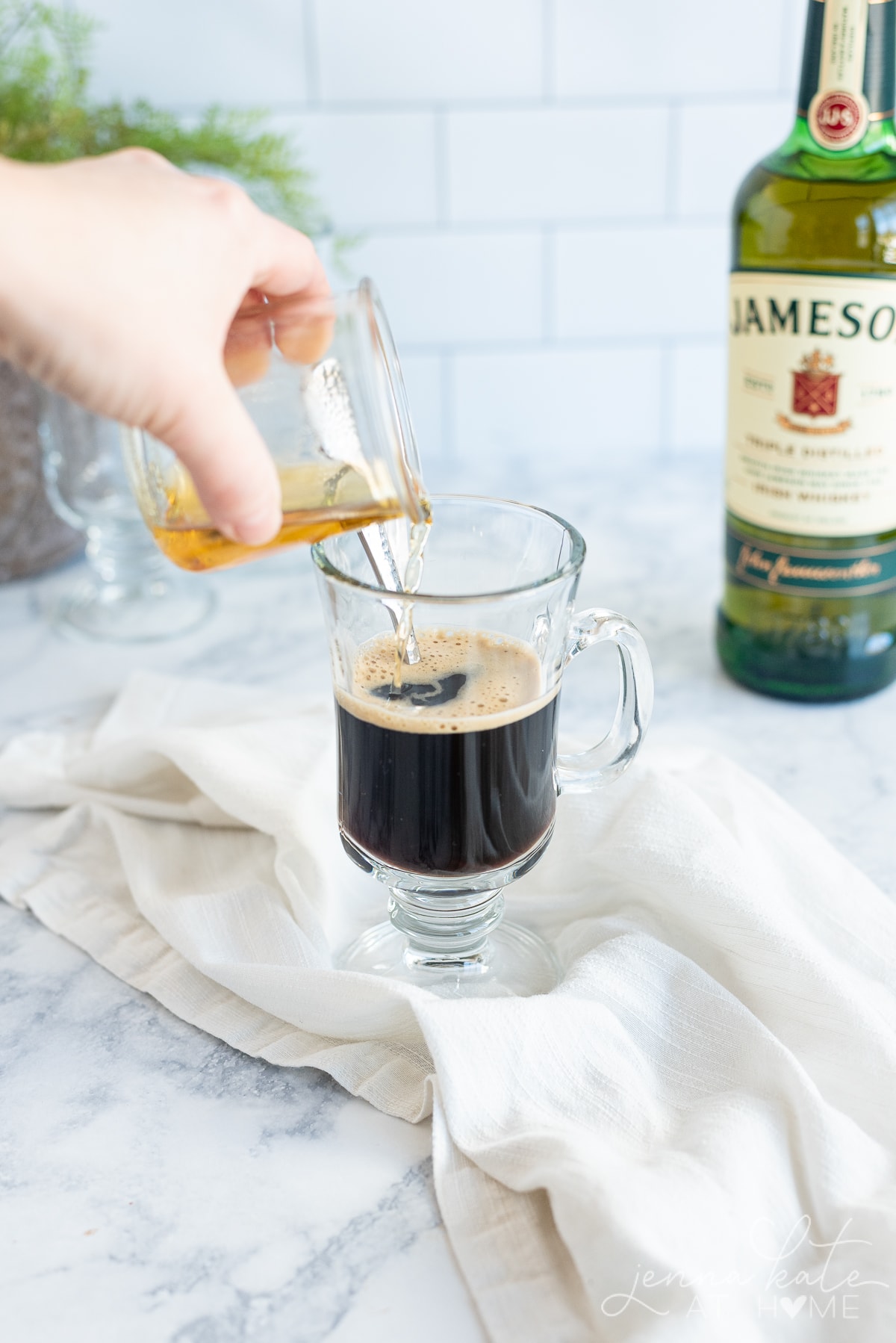 Pouring whiskey into the black coffee