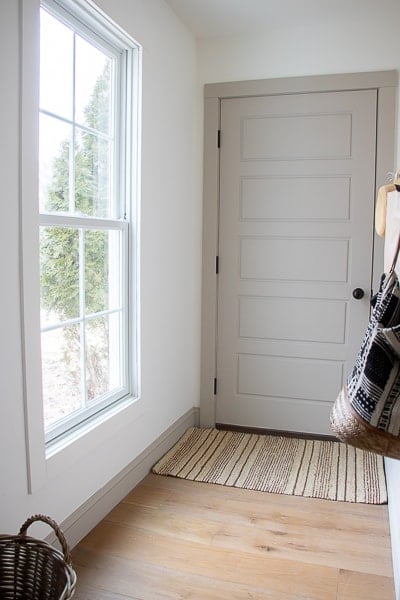 mudroom with white walls and warm greige trim and door