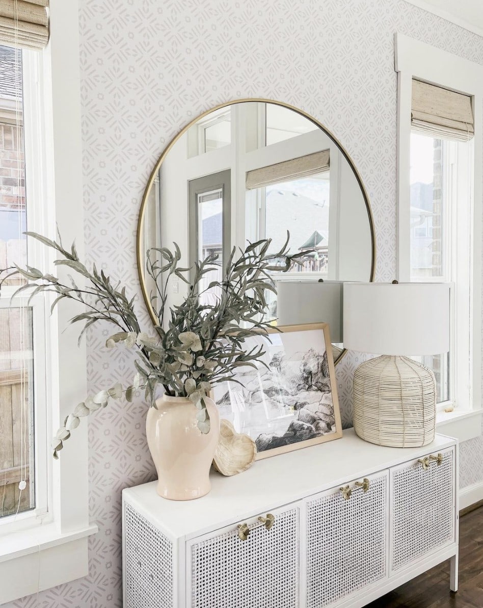 large round mirror over a console table