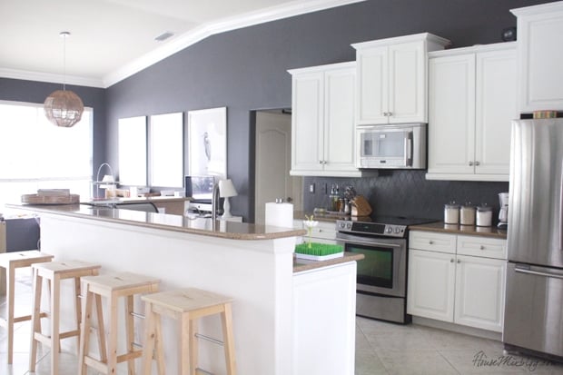 a kitchen with cool white kitchen cabinets and charcoal painted walls