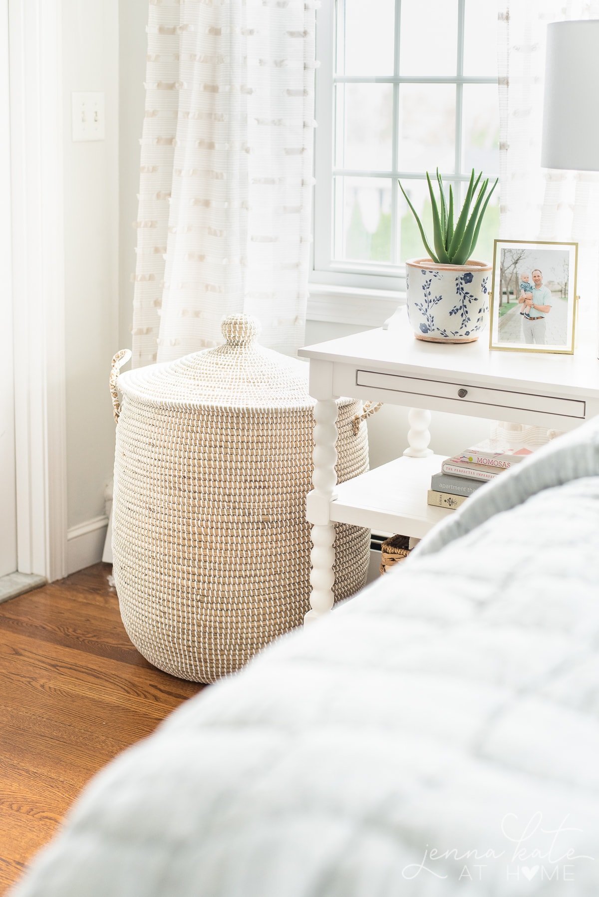 rattan linen basket in the corner of a bedroom
