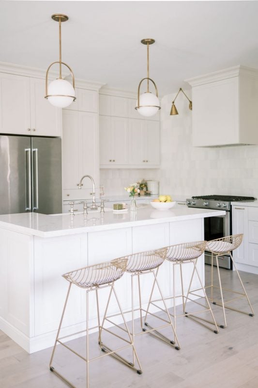 a kitchen with the walls and island painted the same bright white