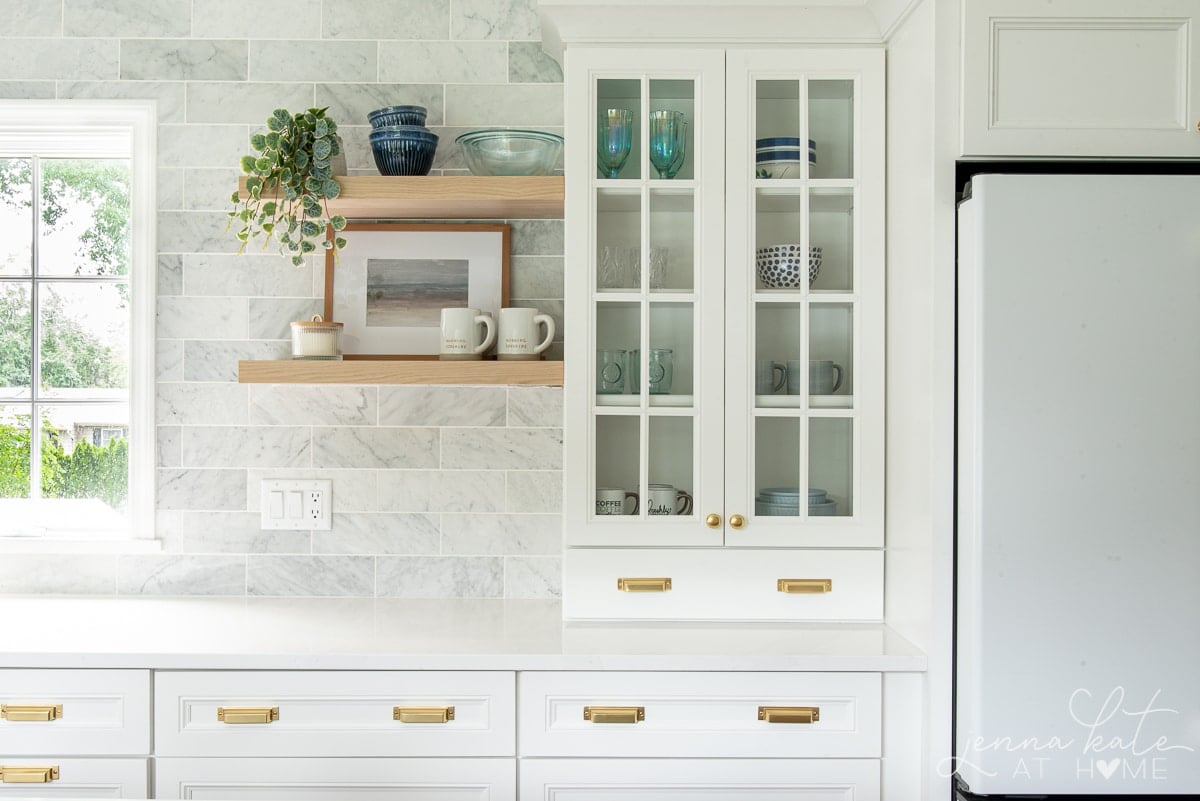 Simply White painted cabinets in a kitchen with gold accents.