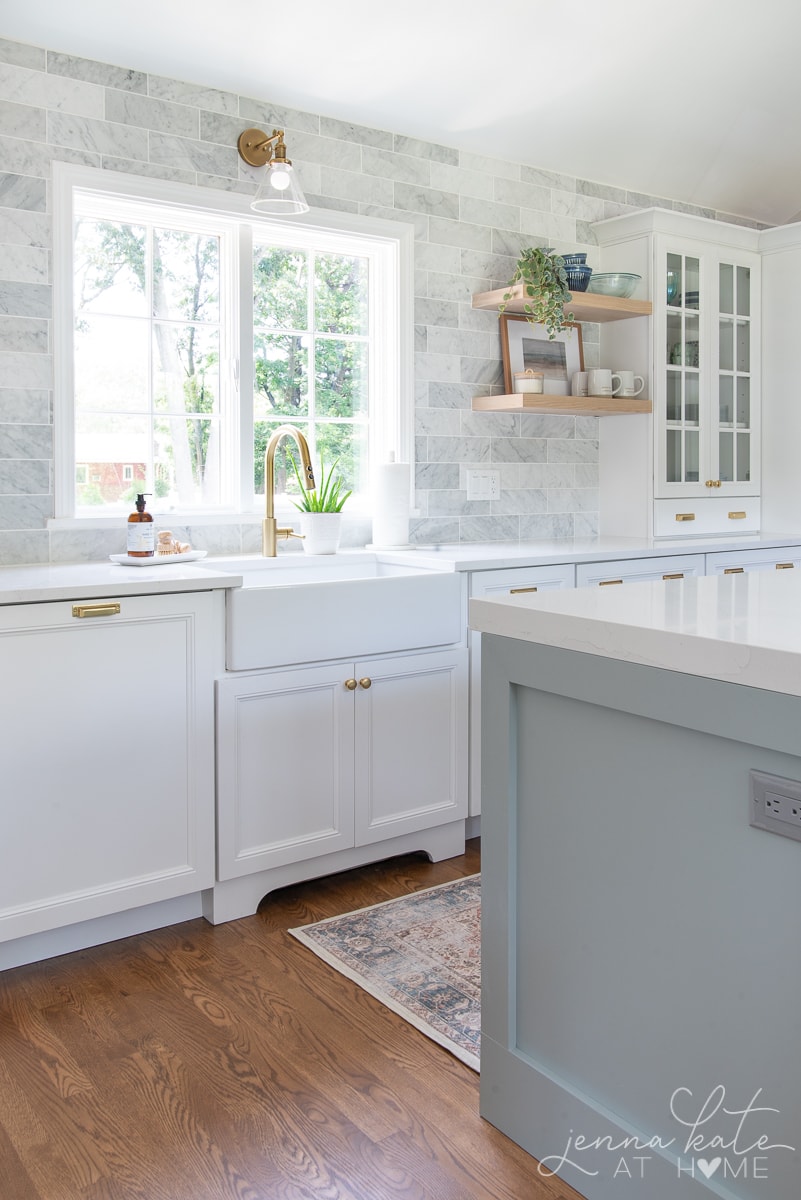 farmhouse kitchen sink and marble subway tile to the ceiling