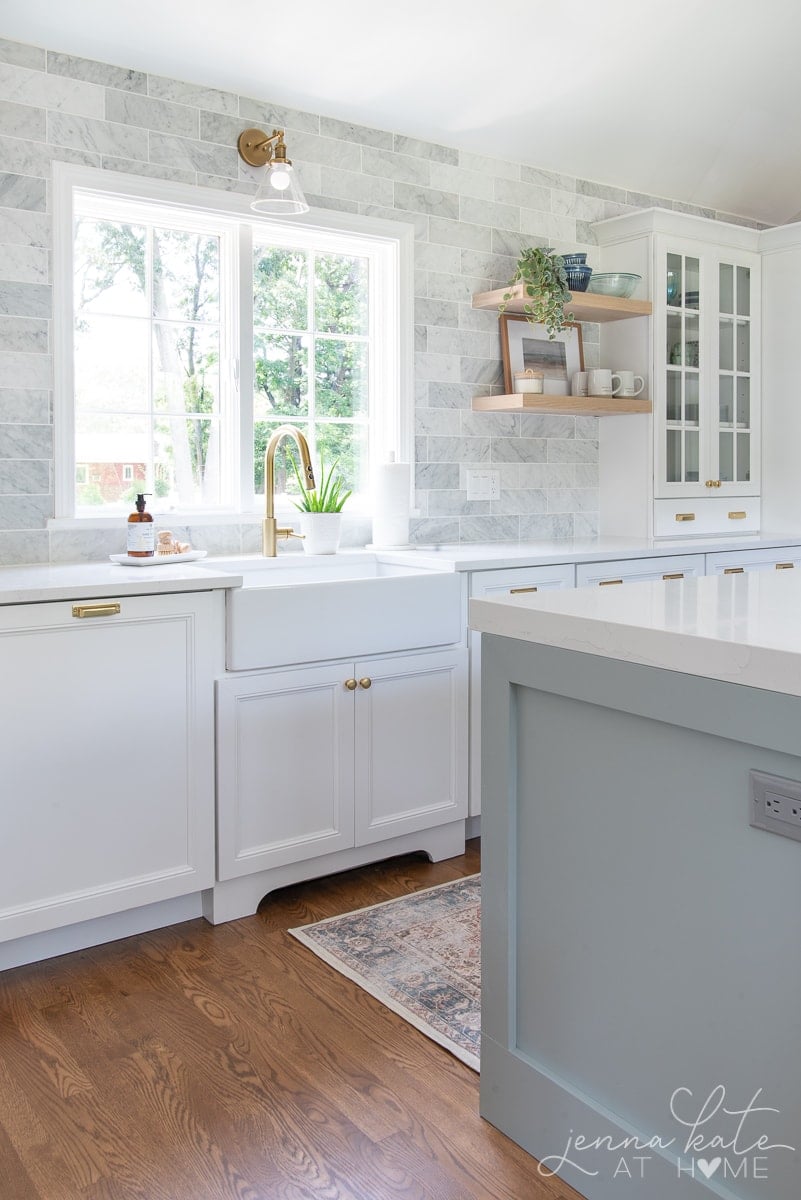 farmhouse kitchen sink and marble subway tile to the ceiling