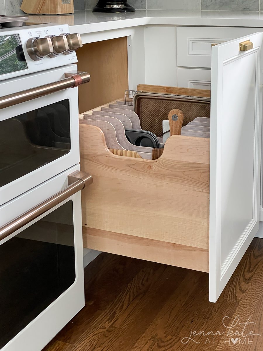 Vertical dividers in a kitchen drawers filled with sheet pans, cutting boards, muffins tins, and more.