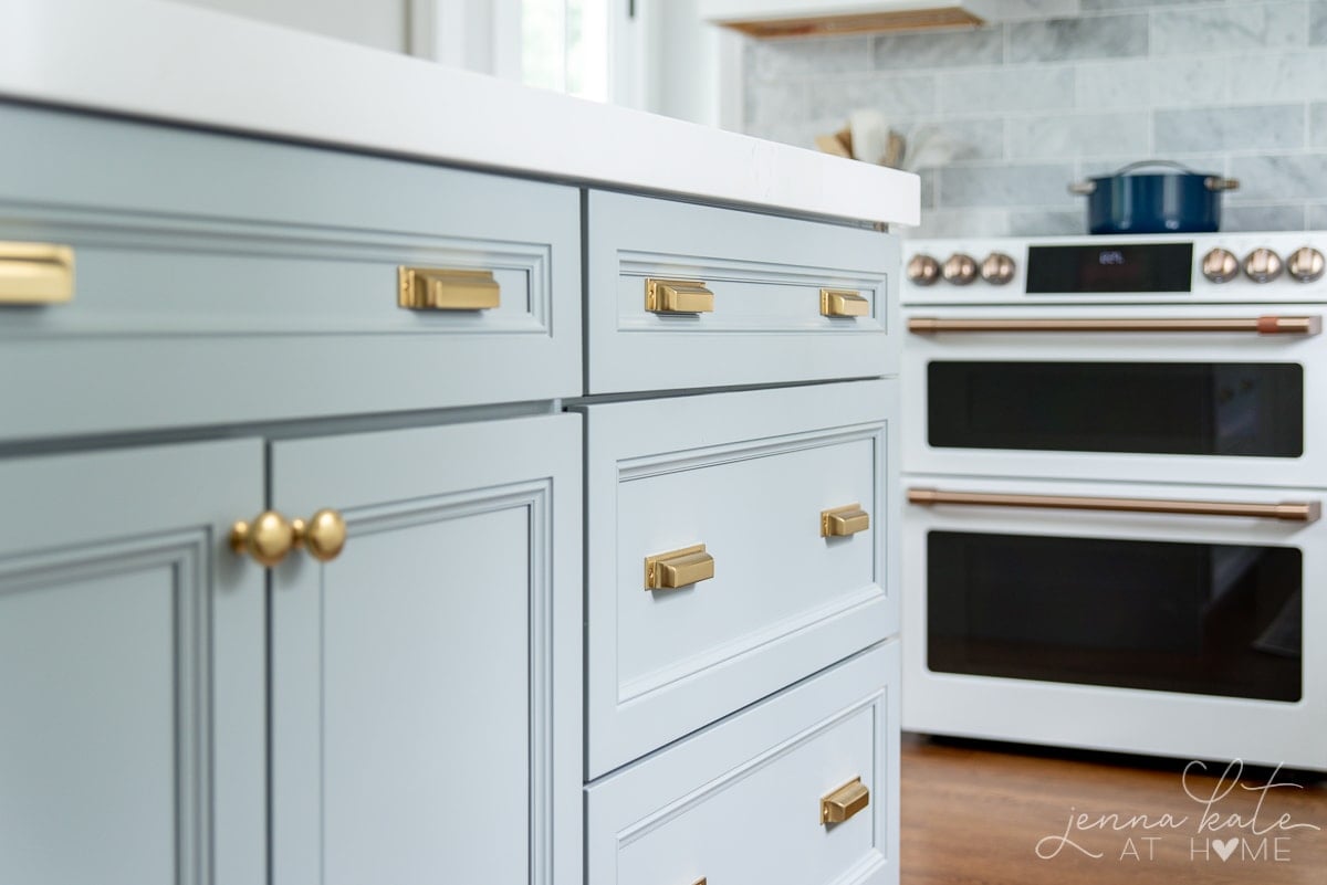 A luxurious white and blue kitchen with gold hardware, Bosch and