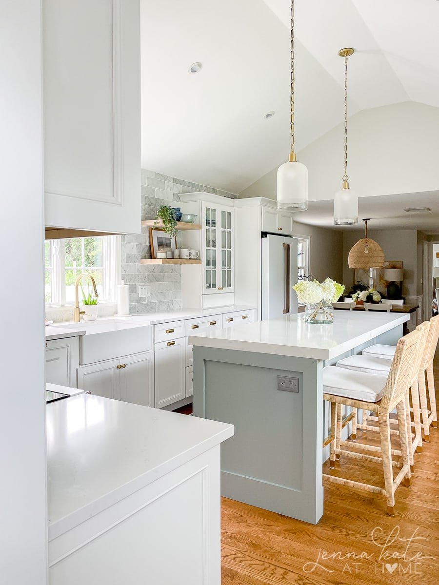 coastal style kitchen with blue island and white cabinets