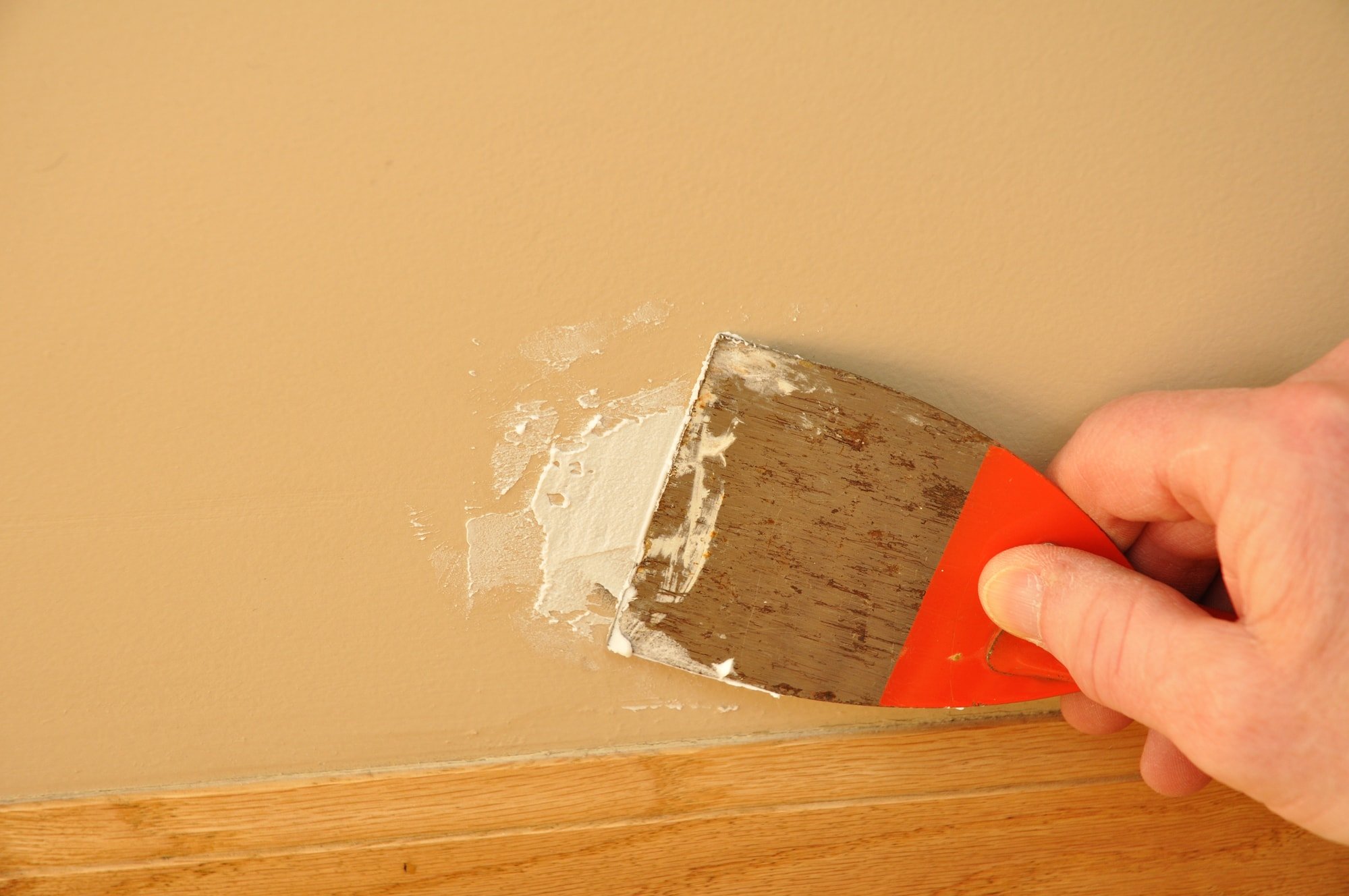Putty Knife with Spackling Paste to Repair Wall Damage