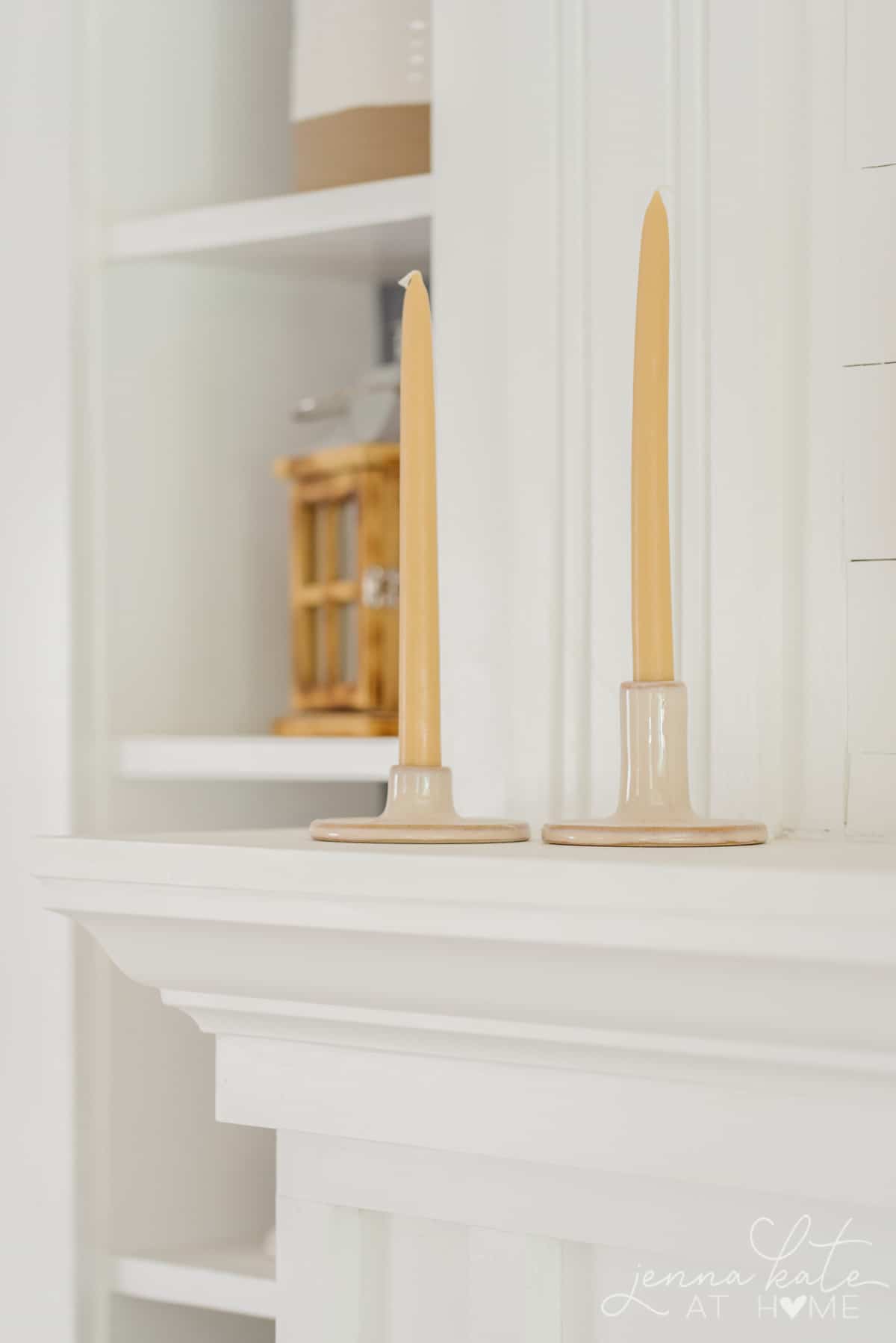 goldenrod candles in candlesticks on the fireplace mantel