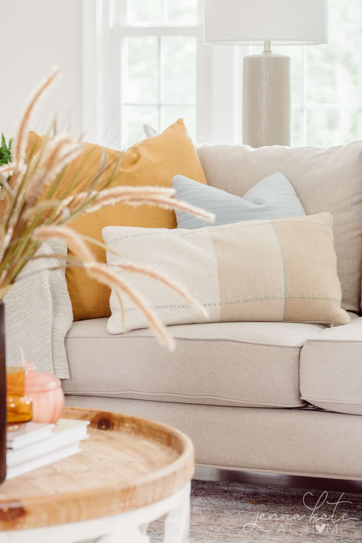 three fall colored throw pillows on the corner of the couch