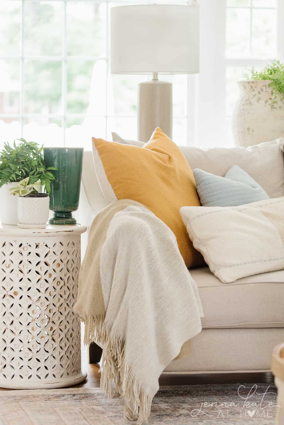 a close up of a yellow and light blue pillow arrangement on a living room sofa