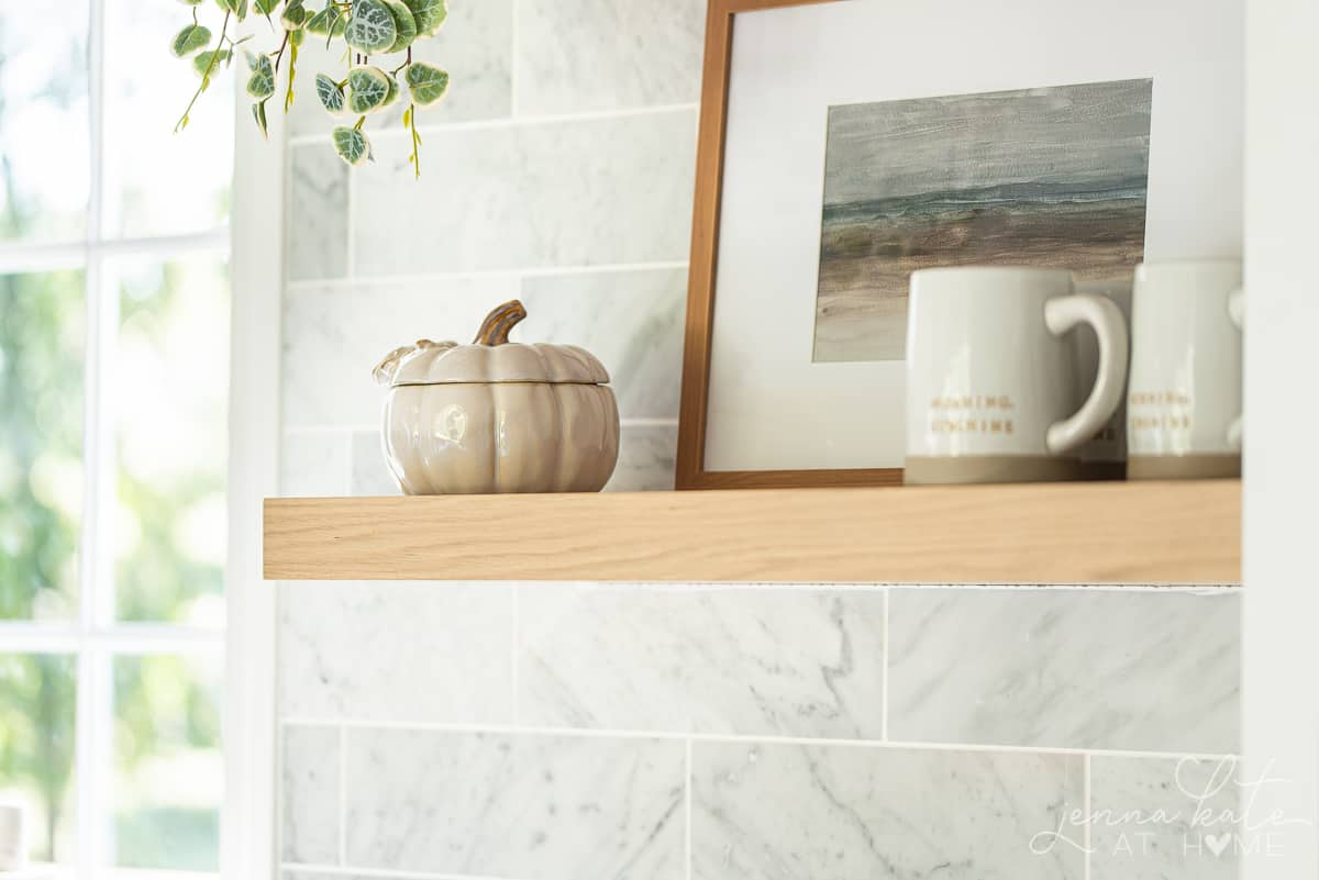 a small ceramic pumpkin on the kitchen floating shelf