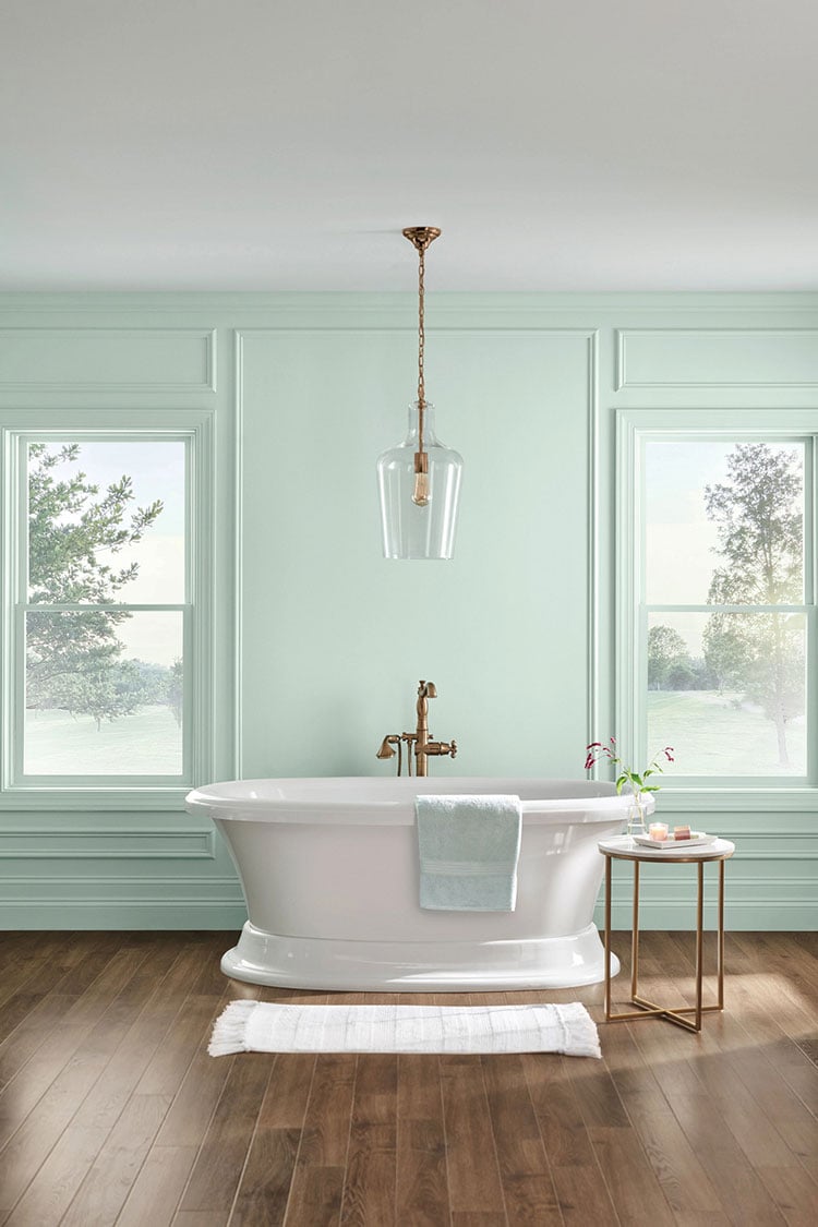 white clawfoot tub in front of floor to ceiling picture frame moulding painted Sherwin Williams Rainwashed