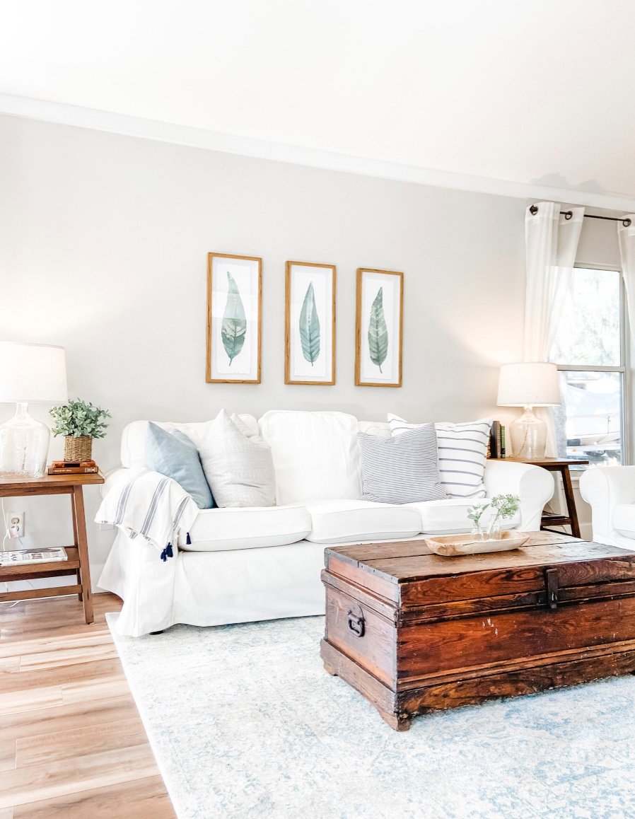 living room walls painted Agreeable Gray with white slipcovered coach and trunk coffee table