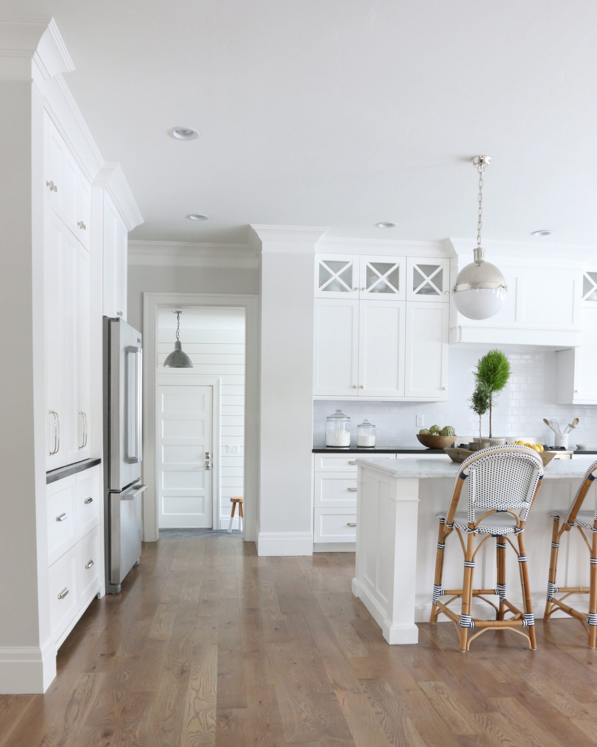 White kitchen with black countertops and french bistro counter stools. Walls are painted Classic Gray.