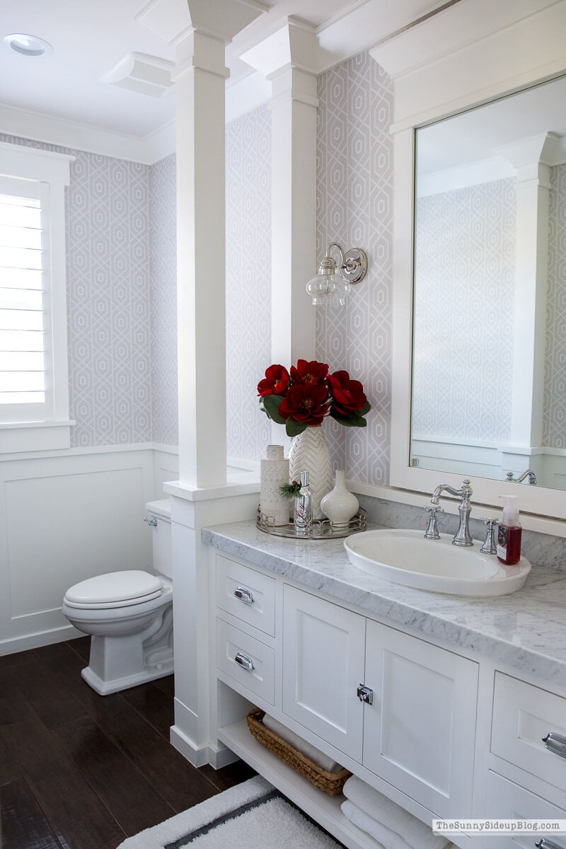 white bathroom and red flowers and red soap set up for Christmas