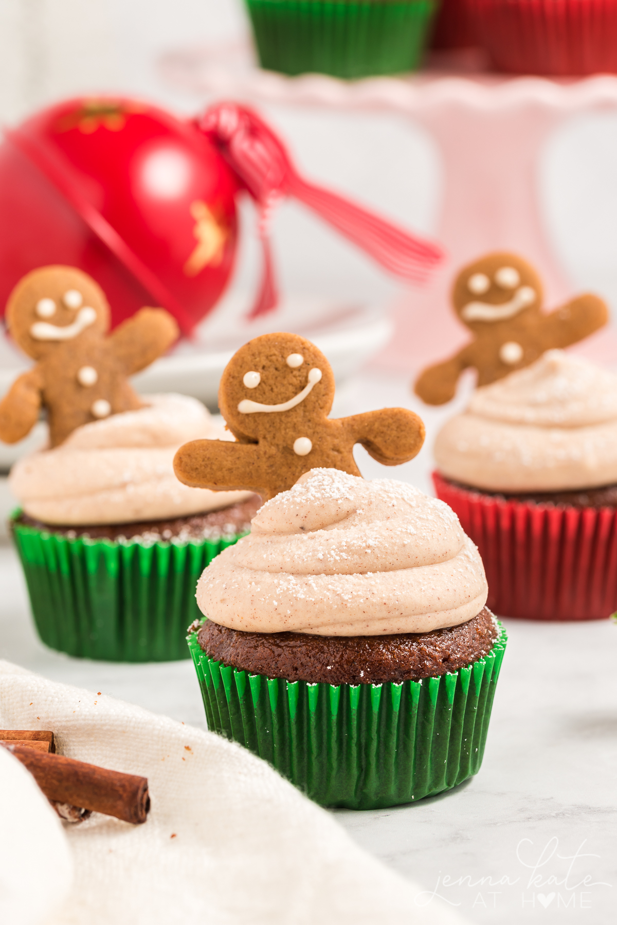 three gingerbread cupcakes decorated with frosting and gingerbread men 