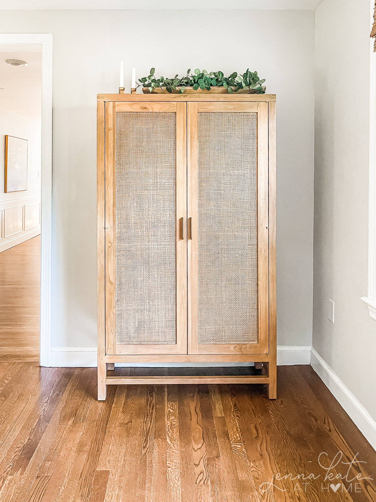 large armoire in front of a wall painted sherwin williams repose gray