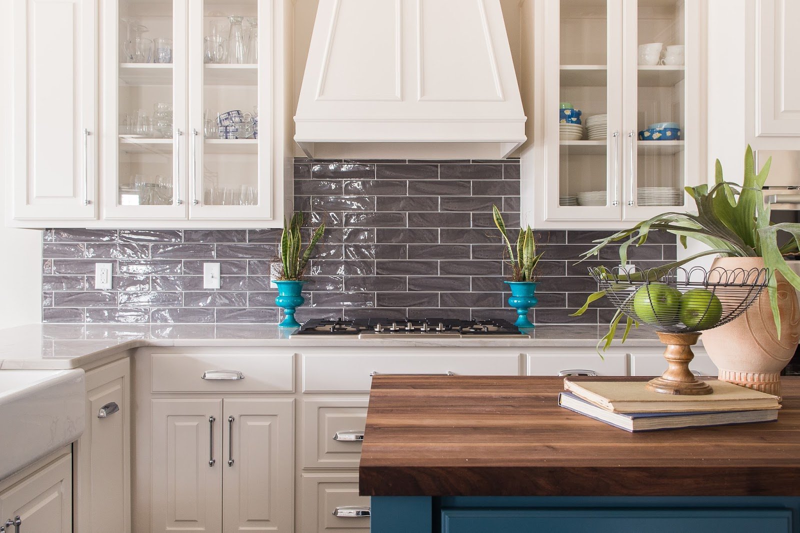 Shoji White kitchen cabinets with dark gray backsplash.