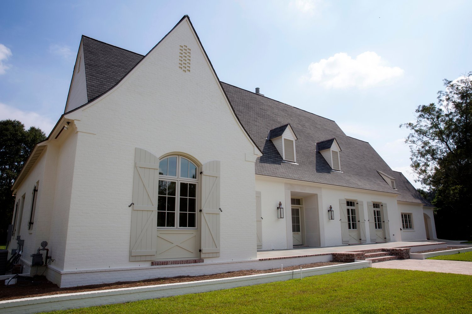 exterior of white home with grey rood and beige shutters green lawn