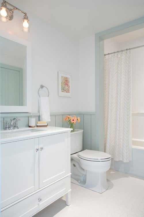 bathroom with green walls and white cabinets