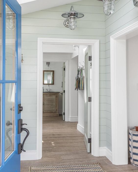 Entryway to beautiful home with blue door, wood floors and green painted walls with white trim