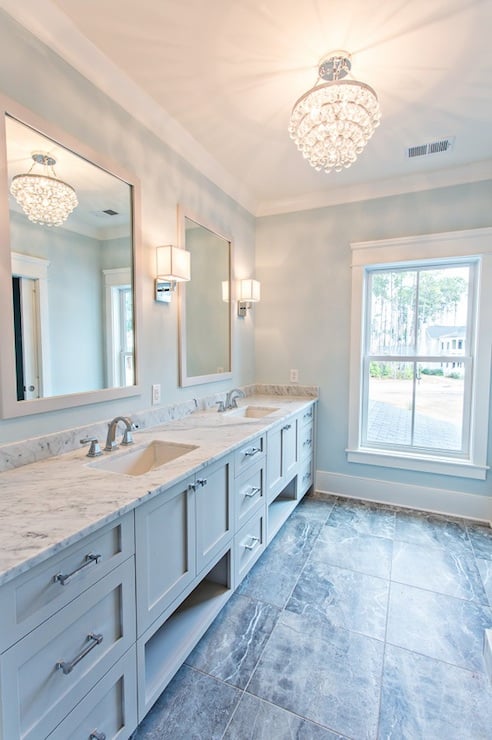 beautiful bathroom  white counters tiled floor and blue cabinets with gray walls