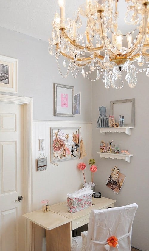 teenage girls bedroom with desk chandelier and shelves with dainty knick knacks