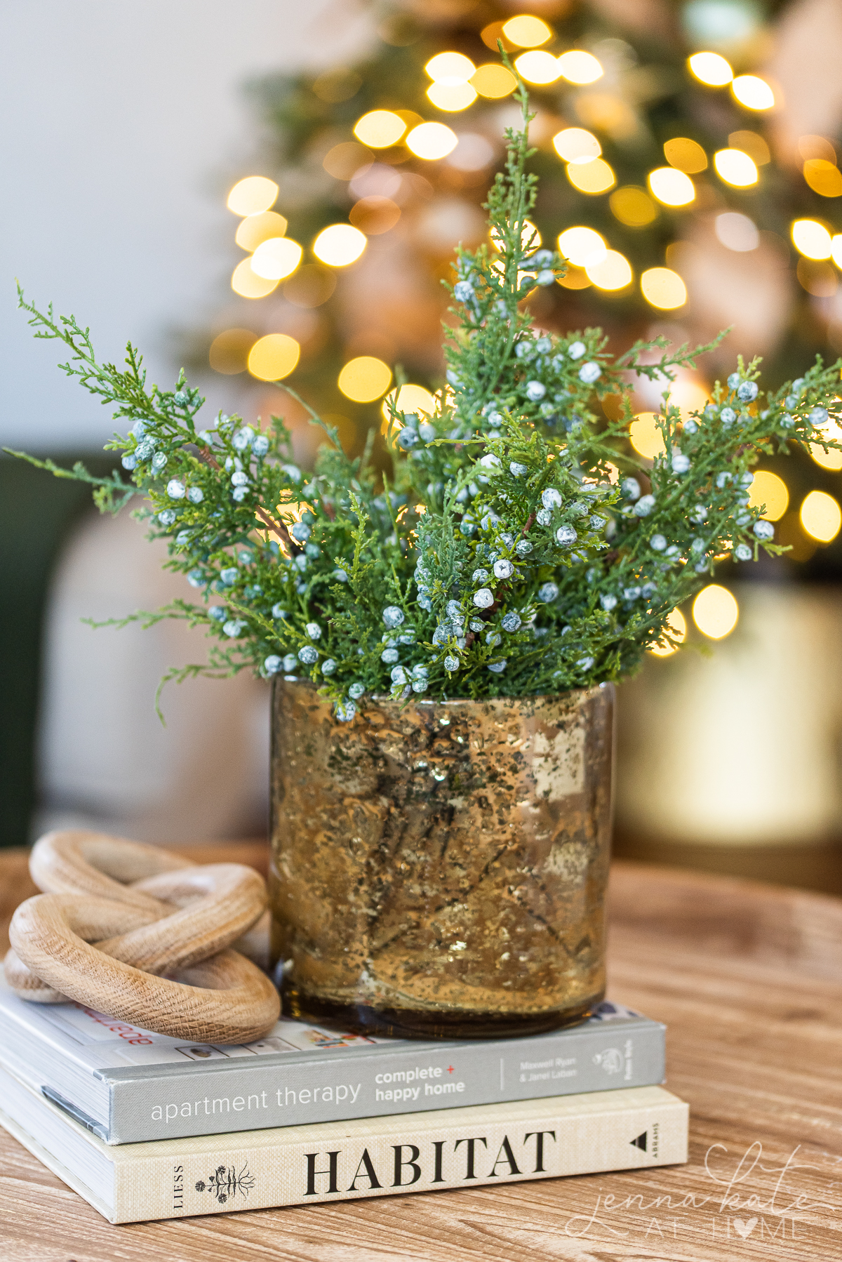 faux juniper branches in a gold vase on a coffee table