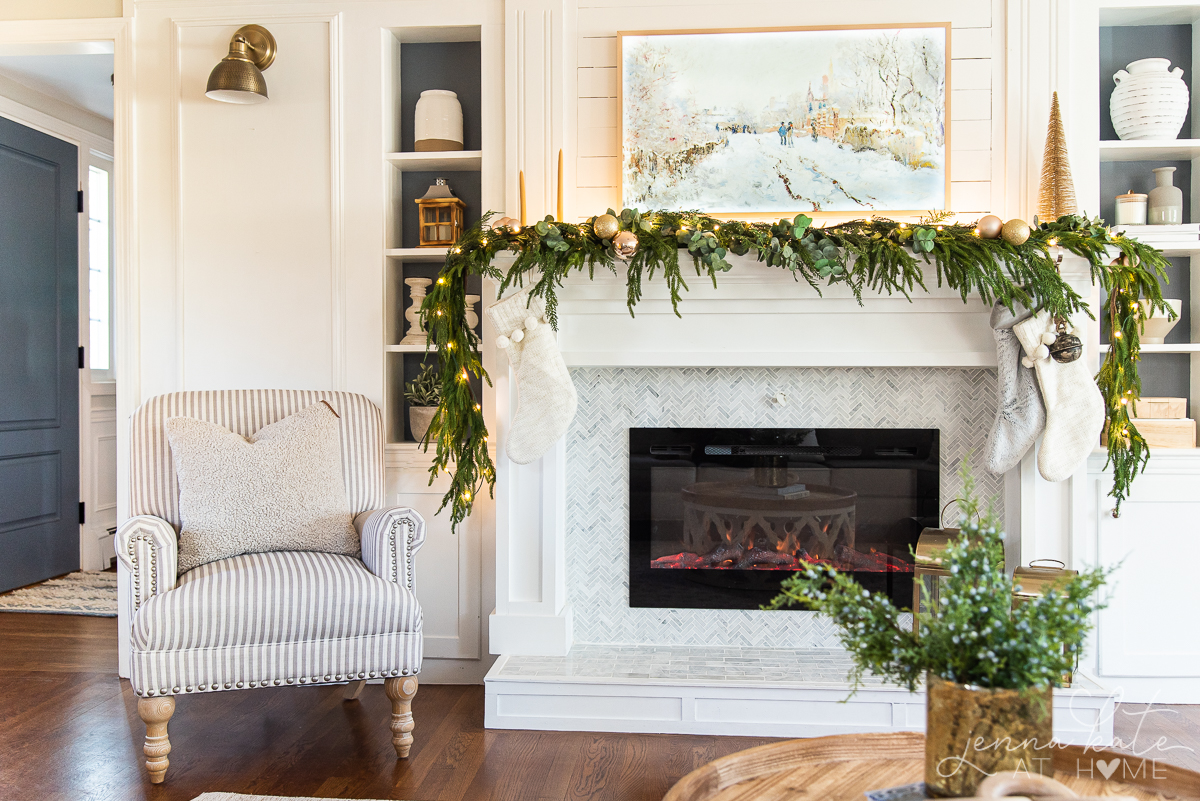 Mantel with garland draped over it and a Frame TV above