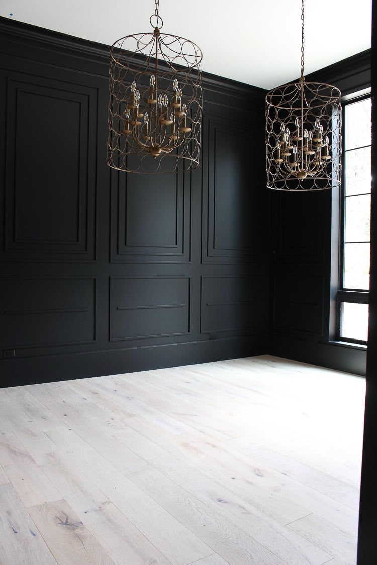 Dining room empty with Tricorn Black walls and chandelier