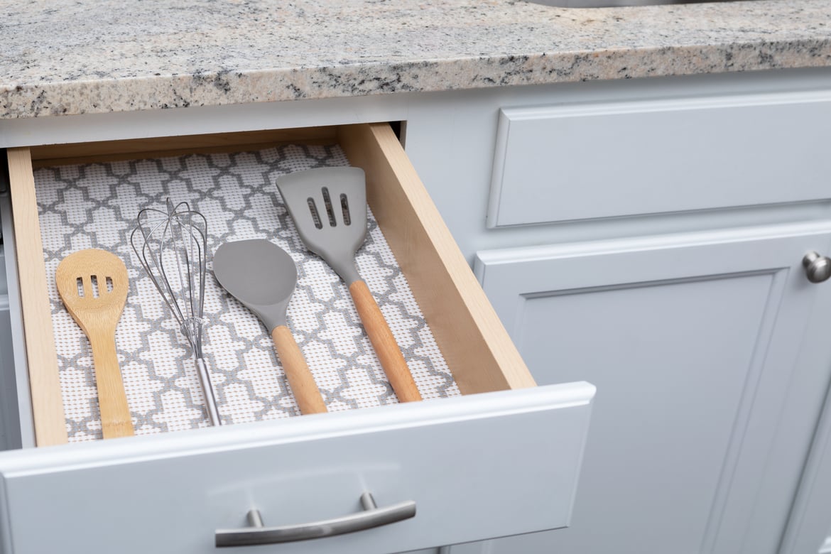 drawer linens white and grey with kitchen utensils in drawer 