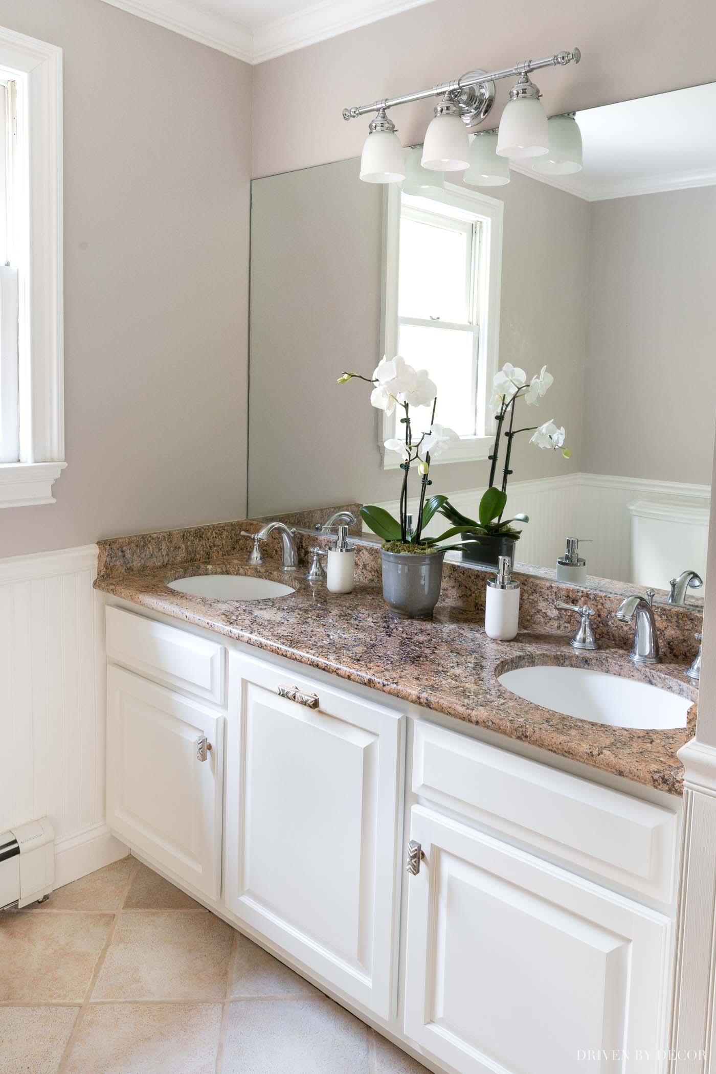 Neutral colored bathroom with vanity, mirror, and sink with walls painted SW Alpaca