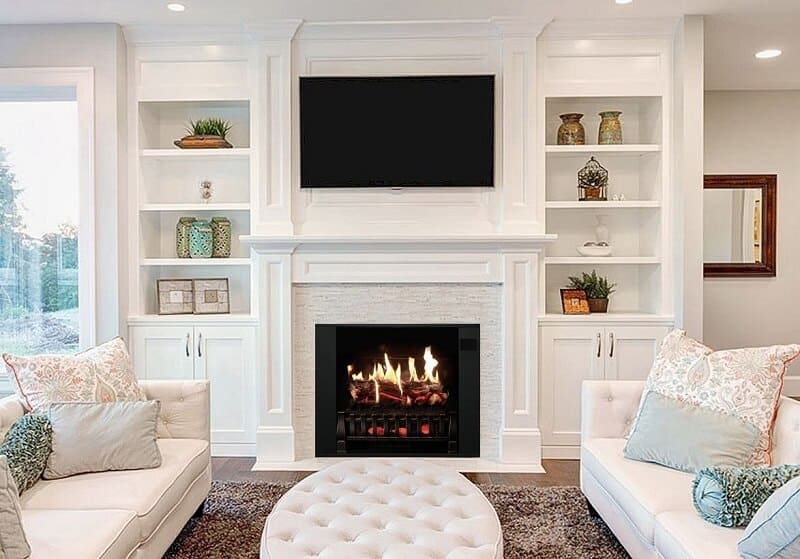 fireplace with fire lit and class built-ins with moulding detail and TV over the fireplace