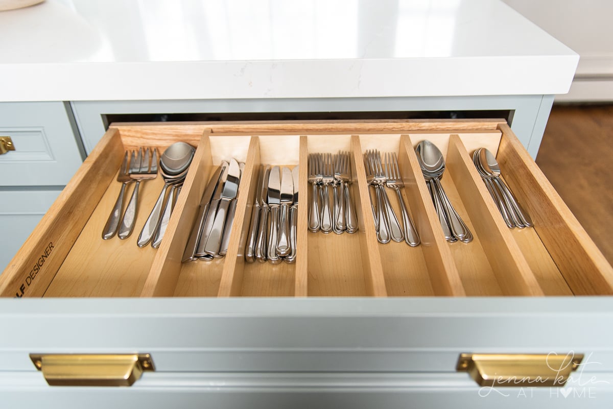drawer with wooden cutlery organizer filled with silver flatware