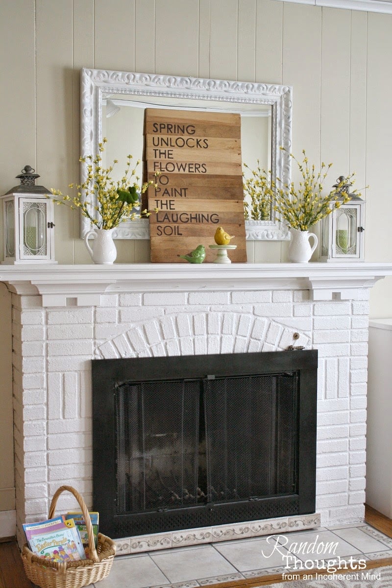 neutral spring mantel with wood toned sign simple yellow florals and white vases and lantern