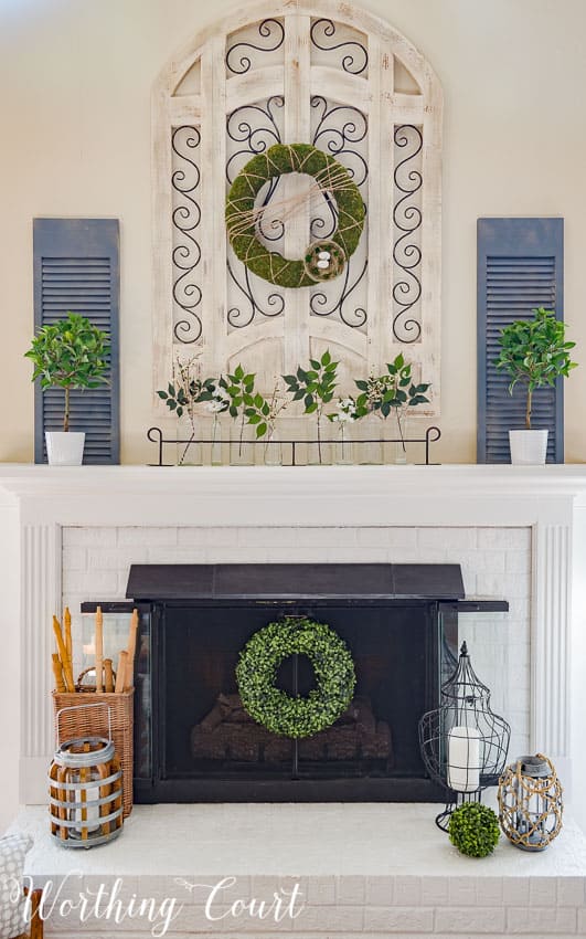 fresh spring mantel with pops of greenery and blue shutters over fireplace 
