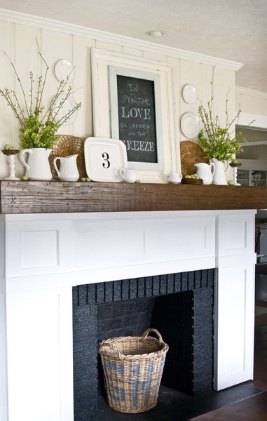 Gorgeous spring mantel with white, wood, and green tones, vintage pitchers with chalkboard