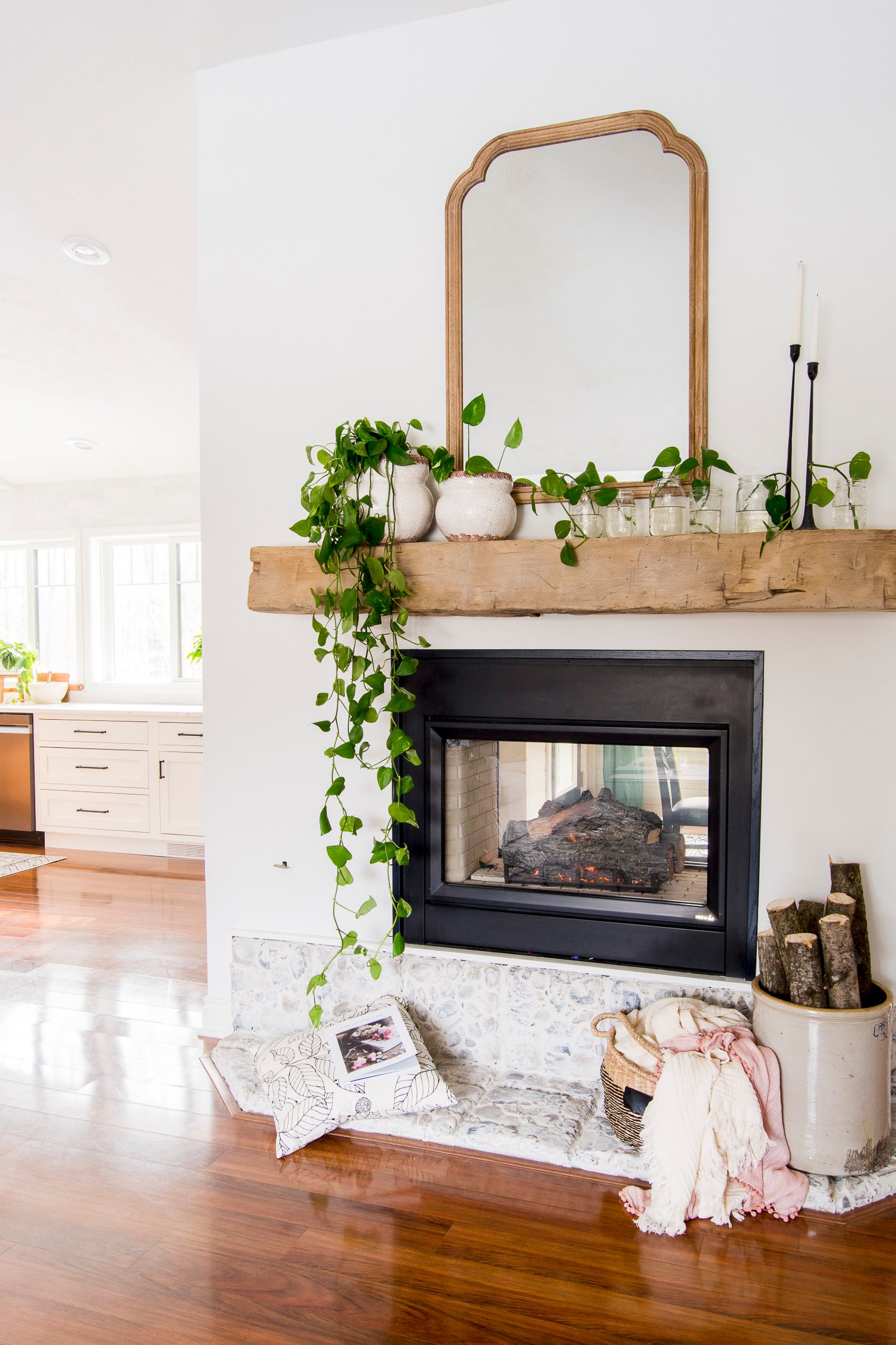 fresh greenery on spring mantel wood mirror and candlesticks