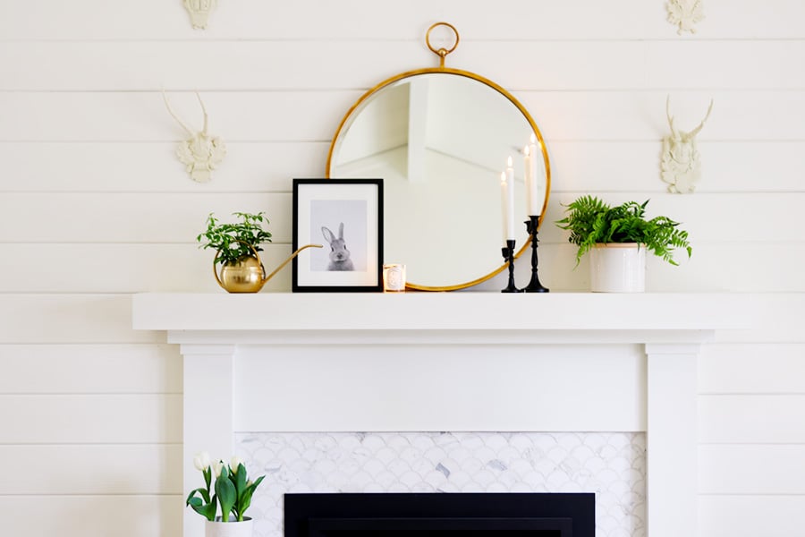 simple white mantel with mirror and few decor accent pieces