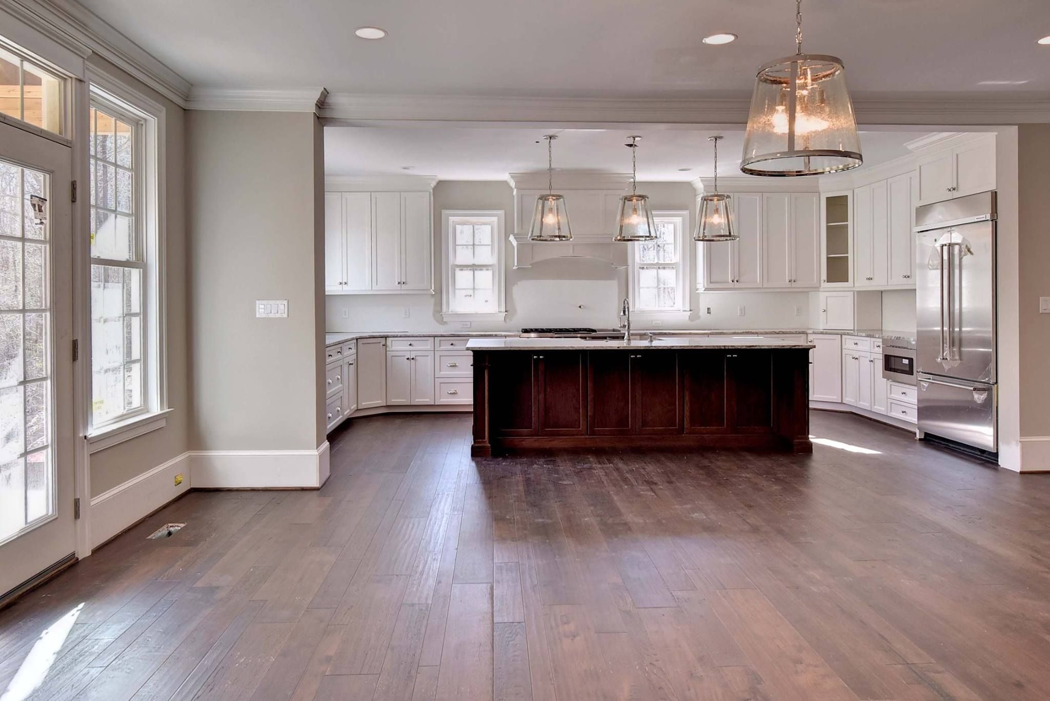 Large kitchen with white cabinetry, large wood island and walls painted Sherwin Williams Agreeable Gray