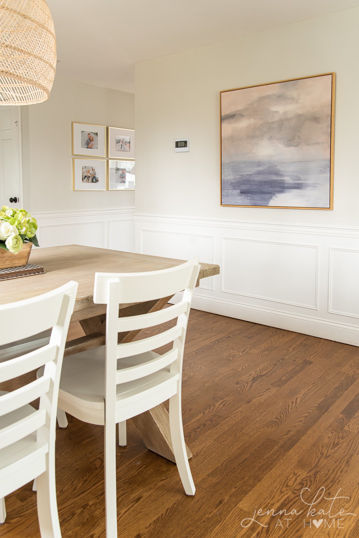 dining room with art on the walls, white wainscoting and walls painted Repose Gray lightened by 50%